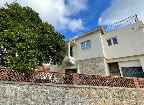 una casa con una pared de piedra y un árbol en Orange Tree house, Silver Coast, Alcobaça, Nazaré, en Alpedriz