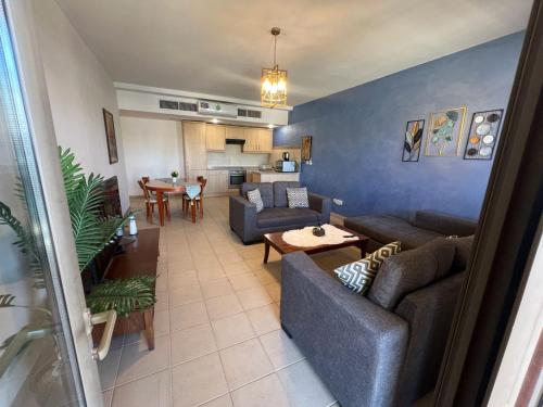 a living room with couches and a table and a kitchen at منتجع تالابيه العقبة in Aqaba