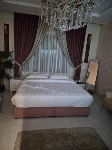 a bedroom with a large bed and a chandelier at استديو ضيوف الرحمن in Makkah