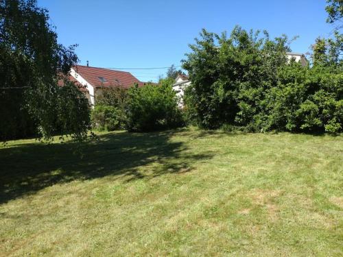 a grassy yard with trees and a large field at La Vernoisienne dans le Jura in Le Vernois