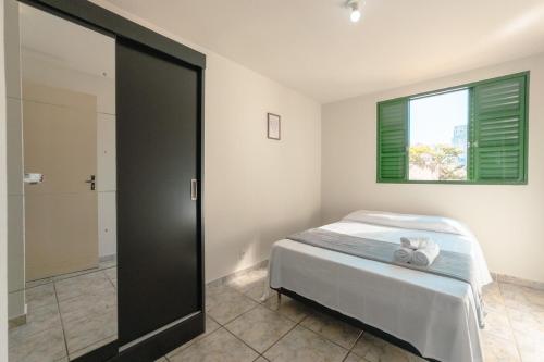 a bedroom with a bed and a window and a shower at Central, Barato e Espaçoso in Maringá