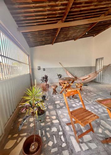 a room with a hammock and a table and chairs at La Palma Hostel in Maragogi