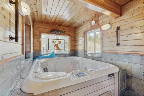 a large tub in a bathroom with wooden walls at Downhill Beaverhead in Big Sky