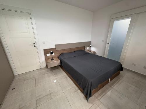 a bedroom with a bed and two white doors at Modern one bedroom Apartment in Żurrieq