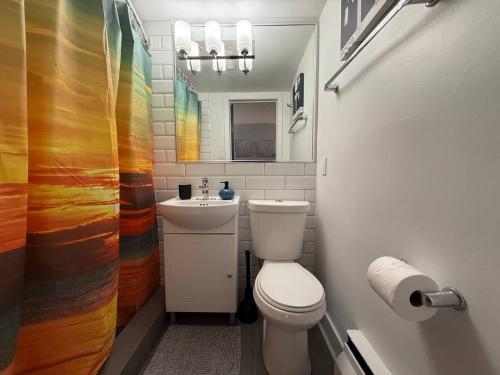a bathroom with a white toilet and a sink at McGill Les petits studios in Montréal