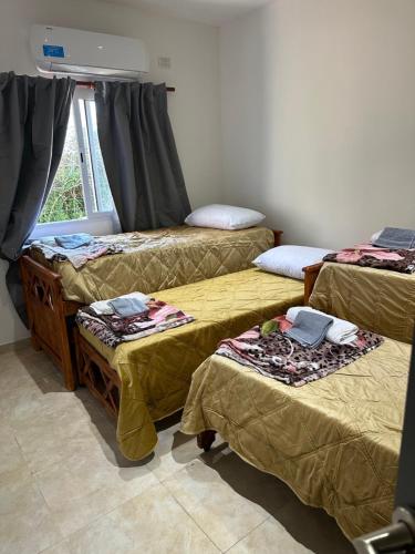 Zimmer mit 4 Betten und einem Fenster in der Unterkunft Aranduroga country club in Corrientes