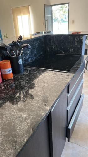 eine Küchentheke mit einer schwarzen Arbeitsplatte in der Unterkunft Aranduroga country club in Corrientes
