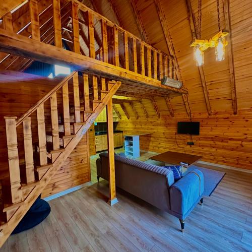 Una sala de estar con un sofá y una escalera. en Willa's Trebisonda Bungalov, en Arsin