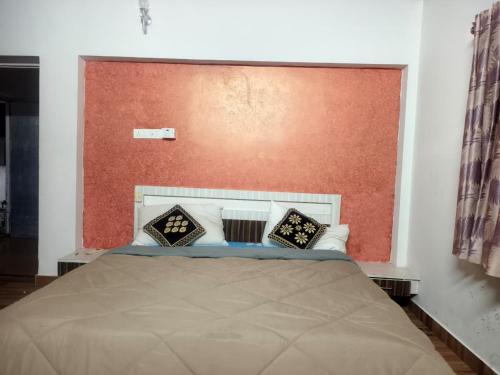 a bedroom with a large bed with a red headboard at SK INN stays in Mahabalipuram