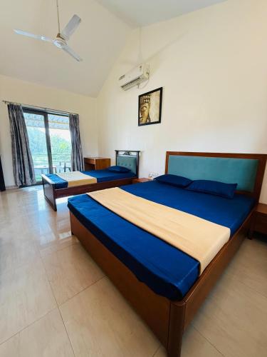 a bedroom with two beds and a large window at Golden Maple Villa in Jāmb