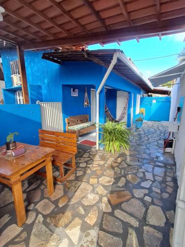 a patio with a wooden bench and a blue wall at Pousada Odoyá Beach - Casal in Conde