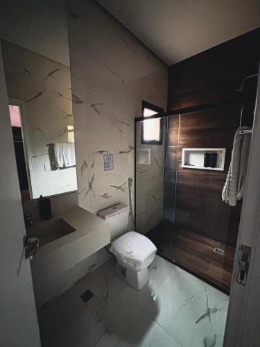 a small bathroom with a toilet and a sink at Hotel Chalés Capitanias in Águas de Lindoia