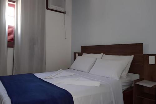 a bed with a blue blanket and white pillows at Casa de Temporada Ceu e Mar in Praia do Bananal