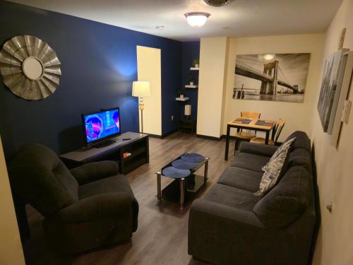 a living room with a couch and a television at Stay Pittsburgh in Pittsburgh