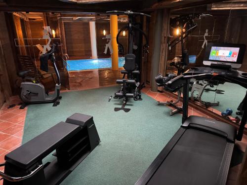 een sportschool met verschillende fitnessapparaten en een vrouw op een loopband bij Sport Hotel Astoria Residence in La Villa