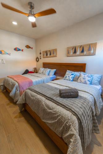 a bedroom with two beds and a ceiling fan at Villas Manglar Sisal 5 by WoWay Experiences in Sisal