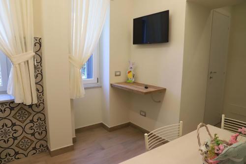 un salon avec une télévision au mur dans l'établissement Domus Marina - Ionio room, à Mondragone