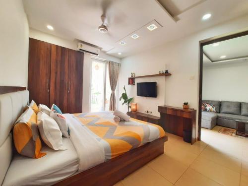 a bedroom with a large bed and a television at Luxury Pool view Apartment w Jacuzzi by Mirabella in Mapusa