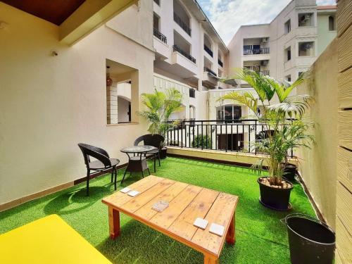 a patio with a table and chairs on a balcony at Luxury Pool view Apartment w Jacuzzi by Mirabella in Mapusa
