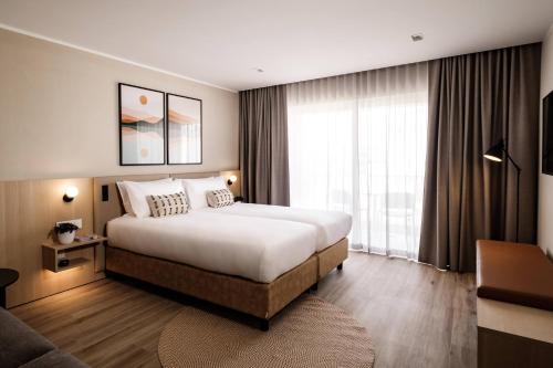 a hotel room with a bed and a large window at Strand Suites by NEU Collective in Il-Gżira