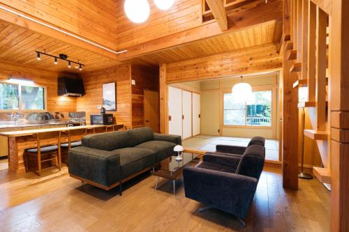 a living room with two couches and a kitchen at KAGUYA Karuizawa - 輝屋 in Naganohara