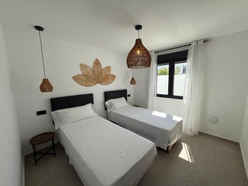 a bedroom with two beds and a window at Villa Jupiter by Albir Proper Properties in Albir