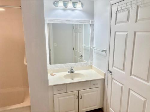 een witte badkamer met een wastafel en een spiegel bij Ocean Walk Resort - Remarkable Ocean Front View in Daytona Beach