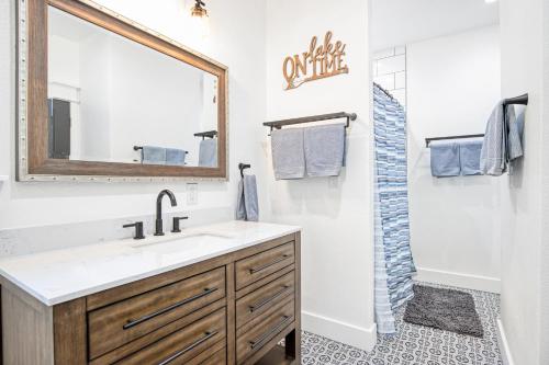 ein Badezimmer mit Waschbecken und Spiegel in der Unterkunft Amazing Sunset Lake Views, Huge Deck & Hot Tub! in Sunrise Beach