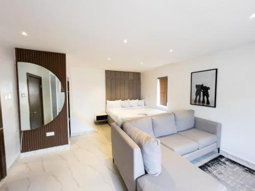 un soggiorno con un divano e un letto di Luxe Apartments Surulere a Lagos