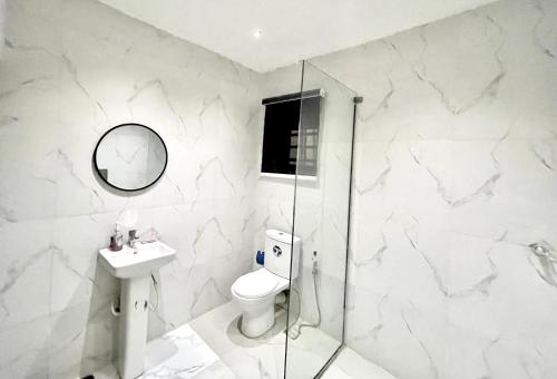 ラゴスにあるLuxe Apartments Surulereのトイレ、洗面台、シャワー付きのバスルーム