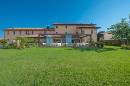 a large house with a large lawn in front of it at Agriturismo coda di gatto in Eraclea