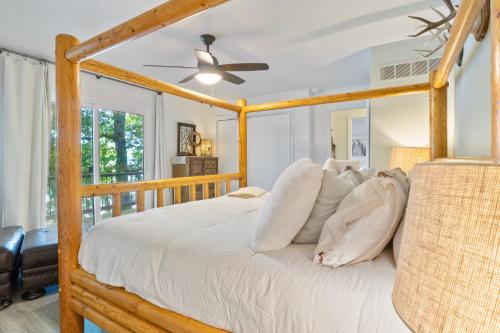 Schlafzimmer mit einem Holzbett und einem Deckenventilator in der Unterkunft Firepit, Kayaks, Paddle Board, Lake Views, Great Location in Purvis