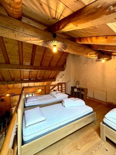 CharchillaにあるGîte Les Plaisirs du Lac avec spa & jacuzziの木製天井の客室の大型ベッド1台分です。