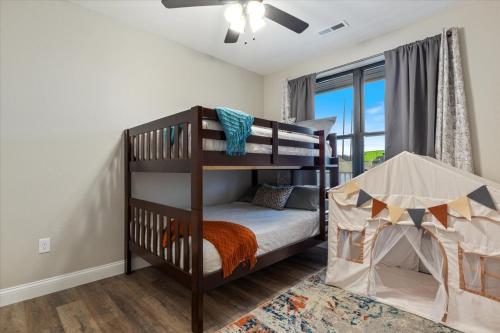 a bedroom with two bunk beds and a window at Family-Fun Lakeside Luxury at Topsider in Osage w/ 2 Pools, Prime Views Pack N' Play & Games in Laguna Beach