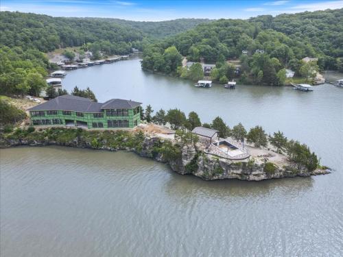 an island in the water with a house on it at Expansive Lakefront Estate with Private Pool & Movie Theater at 43mm in Purvis