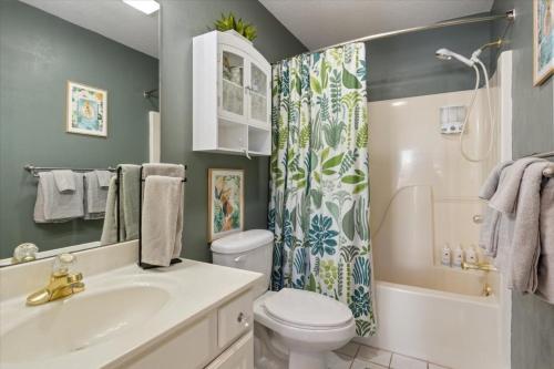 Un baño con lavabo, inodoro y ducha. en Amazing Wall of Windows, Swim Dock & Pet Friendly, en Arrowhead Beach