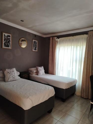Un dormitorio con dos camas y una ventana en Muhle Guesthouse, en Giyani
