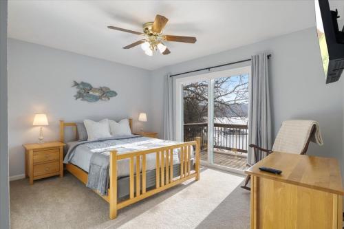 een slaapkamer met een bed, een plafondventilator en een raam bij Expansive Deck, Beautiful Views, Private Dock & Boat Slip in Sunrise Beach