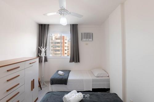 Un dormitorio con dos camas y un ventilador de techo. en Apto c/ balcón y vista al mar en Guarapari CMD0311, en Meaípe