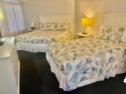 a bedroom with two beds and a lamp on a table at Ocean Walk Resort - Fabulous Ocean Front View in Daytona Beach