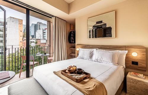 a hotel room with a bed and a balcony at Kukun Edition Marsella Juarez in Mexico City