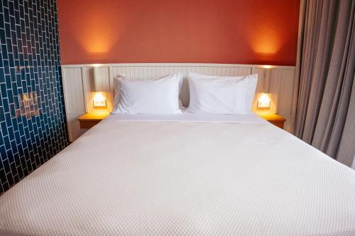 um quarto com uma grande cama branca com duas lâmpadas em Zapadilly Tree Hotel em San Andrés