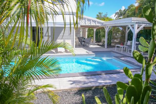 een zwembad in de achtertuin van een huis bij La Petite Villa Guadeloupe in Sainte-Anne