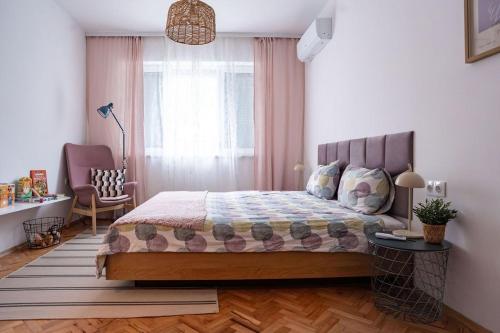 a bedroom with a bed and a chair and a window at Cozy in Varna in Varna City