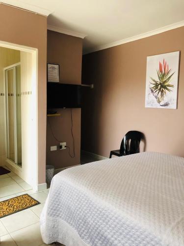 1 dormitorio con cama blanca y pared negra en Bothoba Bed and Breakfast, en Maseru