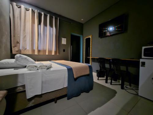 a hotel room with a bed with towels on it at Pousada D'san in Vinhedo