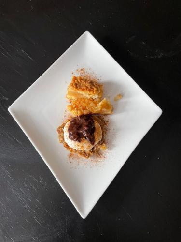 een wit bord met een stukje eten erop bij Villatopol Art Hostel in Rząska