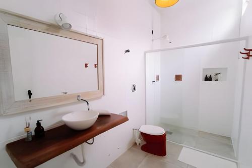 a white bathroom with a sink and a mirror at CASA MANGARITO in Ubatuba