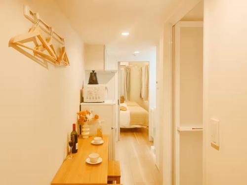 a kitchen with a table and a room with a bed at Minami Ikebukuro APT Dear Cosmo Ikebukuro subway 6mins in Tokyo