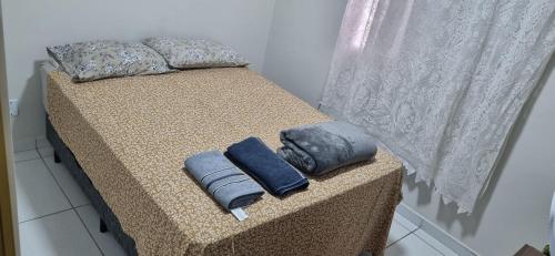 ein Bett mit zwei Kissen darauf in der Unterkunft Apartamento em Condomínio - 2 Quartos - Porto Feliz-SP- 1 Vaga in Pôrto Feliz
